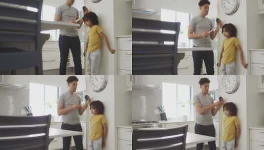 快乐的混血儿和他的儿子在厨房测量身高高清在线视频素材下载