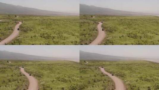 Safari旅游汽车停在路边，靠近Ngorngoro山脊山上的许多长颈鹿高清在线视频素材下载