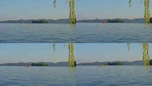 夕阳下的西湖垂柳与湖面游船慢镜头高清在线视频素材下载
