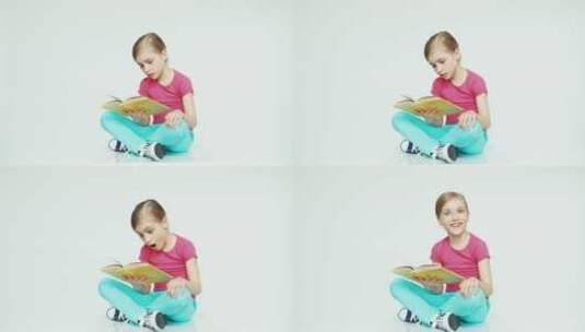 女孩在地上读本高清在线视频素材下载