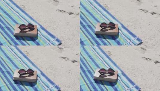 躺在海滩上的太阳镜、书籍、毛巾和海滩设备的视频高清在线视频素材下载
