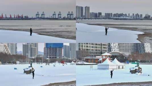 雪地中人物在雕塑旁举手的景象高清在线视频素材下载