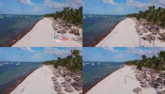 满是日光浴床的沙滩，加勒比海上的船只，多米尼加共和国蓬塔卡纳的巴瓦罗度假村，高清在线视频素材下载