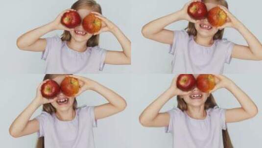 小女孩用两个苹果挡住眼睛高清在线视频素材下载