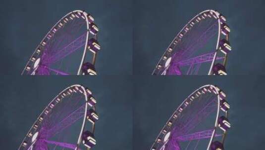紫色摩天轮中景，夜间地面侧拍。里昂摩天轮高清在线视频素材下载