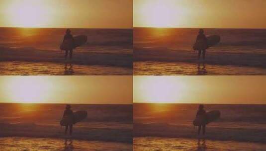 冲浪者在日落时走进大海高清在线视频素材下载