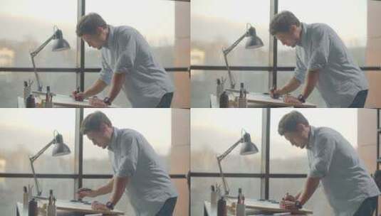 男人站在办公桌前画图纸高清在线视频素材下载