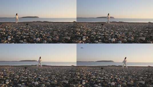 在海边石头滩漫步的游人，夕阳下的浪漫傍晚高清在线视频素材下载