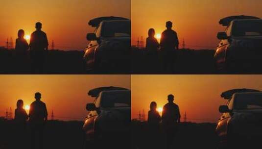 一对年轻夫妇站在他的汽车附近，欣赏宾馆的日落高清在线视频素材下载