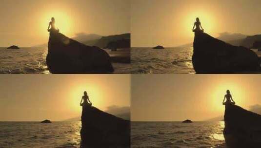 夕阳下女孩在海边岩石上打坐冥想高清在线视频素材下载