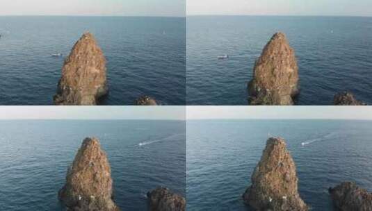 空中POI，陡峭的岩石岛屿，附近有小船高清在线视频素材下载
