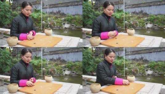 中式胡同四合院女人摆弄棋子高清在线视频素材下载