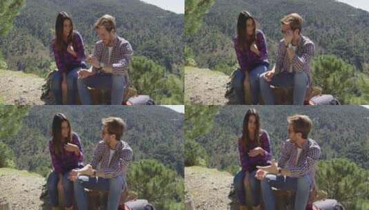 年轻夫妇在山上的石头上休息高清在线视频素材下载