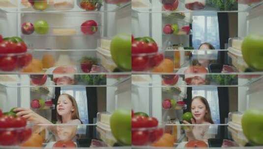 厨房里快乐的年轻女孩打开冰箱门，吃健康的高清在线视频素材下载
