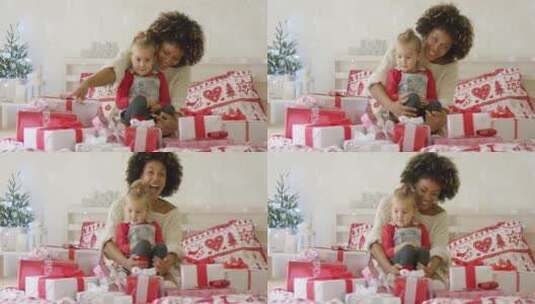 女儿和母亲坐在床上看圣诞礼物高清在线视频素材下载