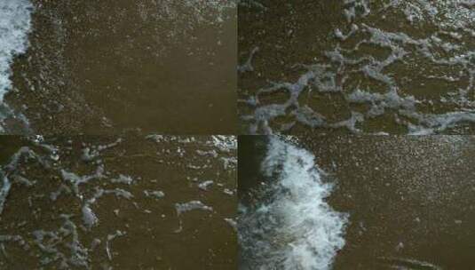 观海岸边，泡沫从水中倾泻到沙滩上，沙滩上的水高清在线视频素材下载
