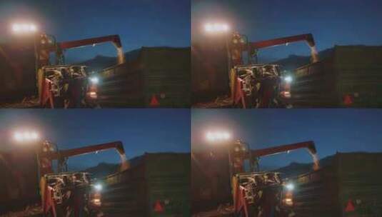 联合收割机夜间将麦子倾倒在拖拉机拖车中高清在线视频素材下载