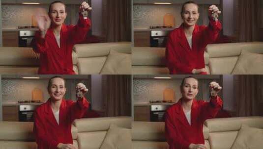 穿着红色西装外套的微笑女人在现代客厅拿着高清在线视频素材下载