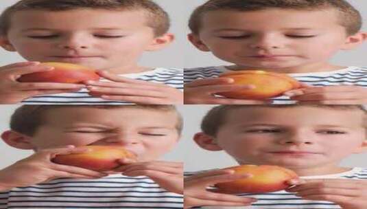 一个小男孩正在把苹果举到鼻子前，闻着它的高清在线视频素材下载