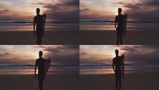 黄昏拿着冲浪板的男人在海滩上散步高清在线视频素材下载