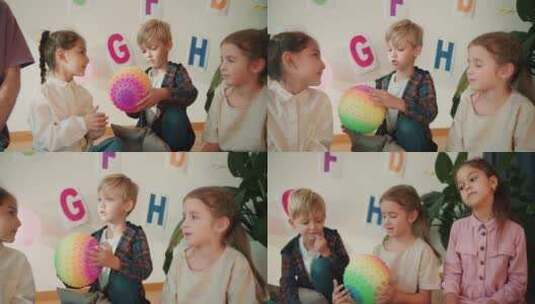 学龄前的小孩子们互相传递一个彩色的球，并高清在线视频素材下载