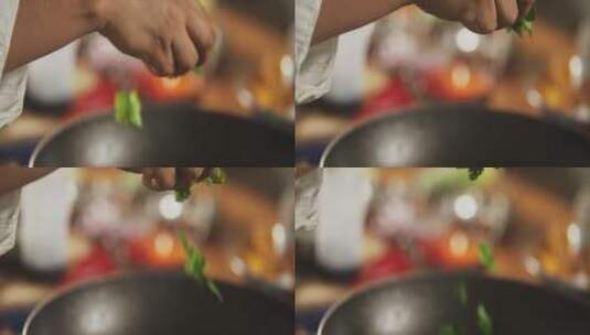 厨师往锅中撒蔬菜的慢动作高清在线视频素材下载