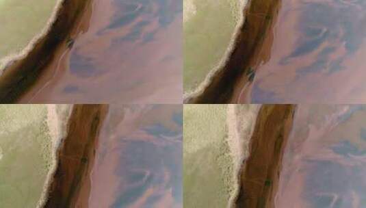 沙丘和草地与红色s之间对比鲜明的深色河流雕刻的顶部向下高清在线视频素材下载