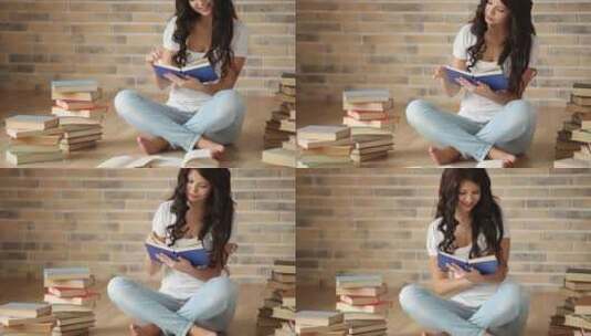 迷人的黑发女孩坐在地板上阅读书籍高清在线视频素材下载