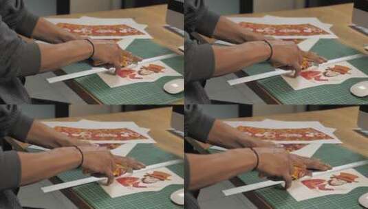 人的手用切割器切割一幅印刷的插图高清在线视频素材下载