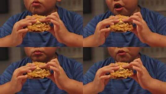 小孩在肯德基大口吃汉堡高清在线视频素材下载