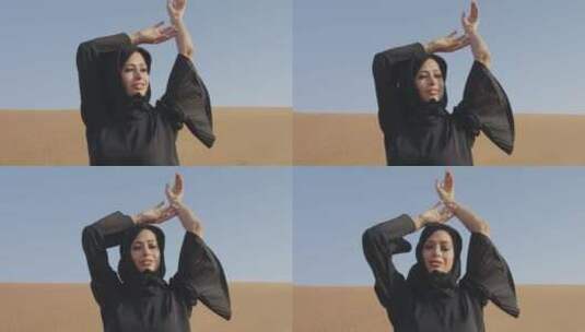 穆斯林妇女在多风的沙漠中摆姿势高清在线视频素材下载