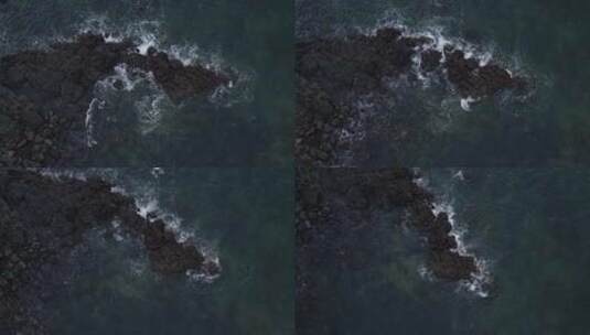 上帝视角下激烈的海浪拍打着黑礁石高清在线视频素材下载