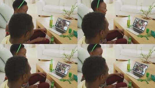 非裔美国夫妇在笔记本电脑视频通话中与朋友庆祝圣帕特里克节高清在线视频素材下载
