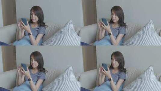 女子沙发上使用手机高清在线视频素材下载