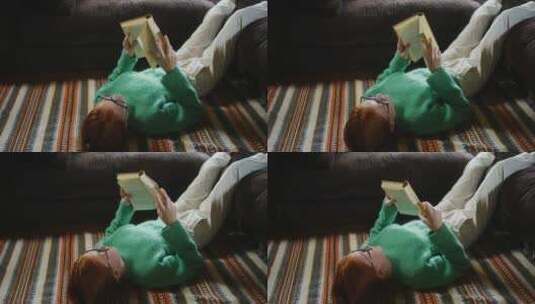 躺在地板上看书的女孩高清在线视频素材下载