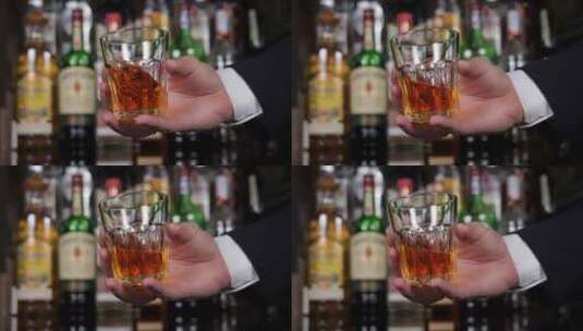 一个穿着夹克的商人在酒吧拿着一杯威士忌的特写镜头高清在线视频素材下载