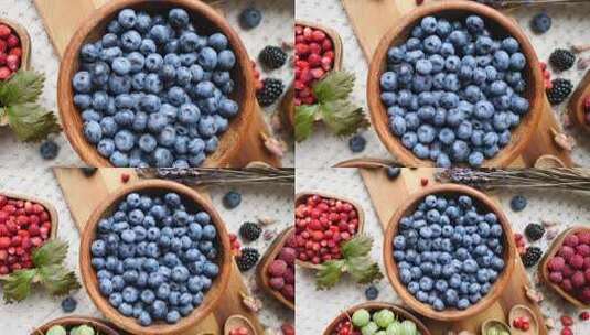 健康食品理念蓝色餐桌上的混合浆果蓝莓高清在线视频素材下载
