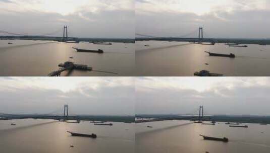 航拍夕阳下的城市跨河大桥轮船划过高清在线视频素材下载