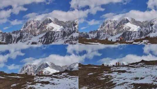 航拍垭口观看贡嘎山区雪山群峰的徒步旅行者高清在线视频素材下载