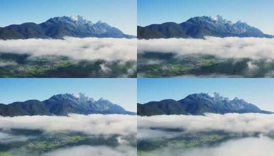 清晨云雾中的玉龙雪山和绿色村庄高清在线视频素材下载