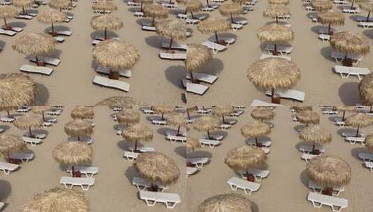 沙滩伞和日光浴浴床的鸟瞰图高清在线视频素材下载