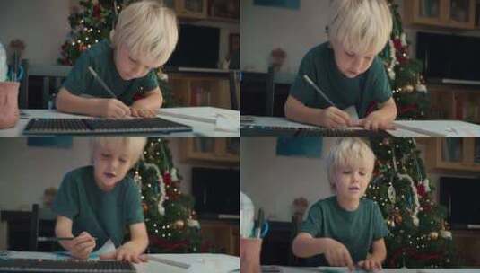 圣诞假期坐在桌旁用铅笔画画的可爱儿童男孩高清在线视频素材下载