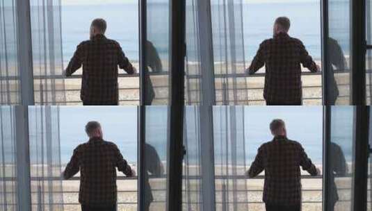 一个男人站在阳台上看着大海高清在线视频素材下载