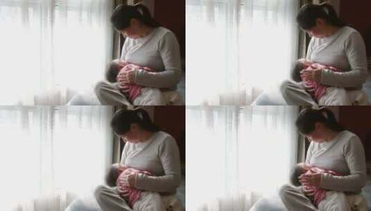 妈妈抱着宝宝窗户边喂奶温馨可爱高清在线视频素材下载