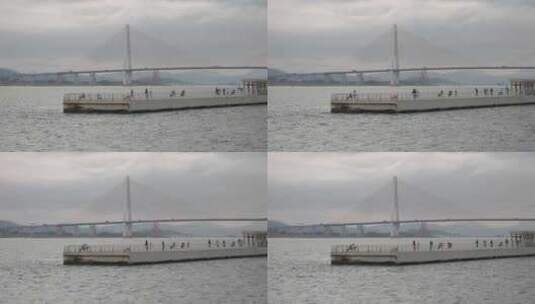 游客在海湾亲水平台眺望大桥打卡拍照高清在线视频素材下载