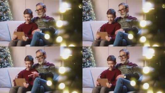 祖父带孩子在圣诞节玩平板高清在线视频素材下载