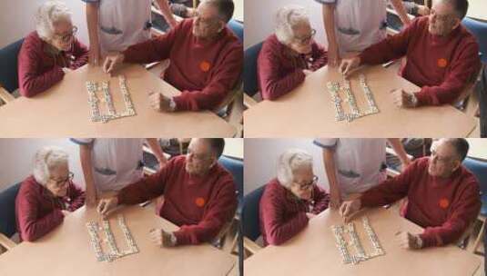 护士在养老院食堂与老年男女玩多米诺骨牌高清在线视频素材下载