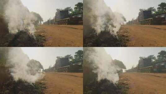 一辆卡车正沿着一条土路行驶，浓烟从中冒出高清在线视频素材下载