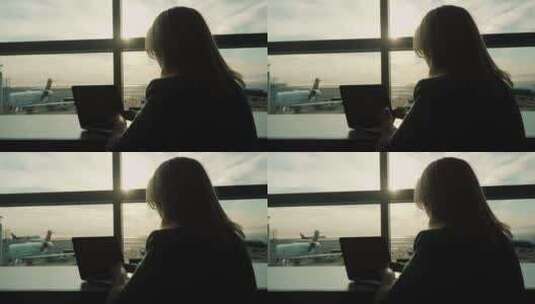 女人坐在机场窗口工作高清在线视频素材下载