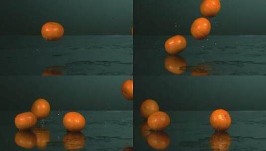 橘子掉落在黑色桌面高清在线视频素材下载